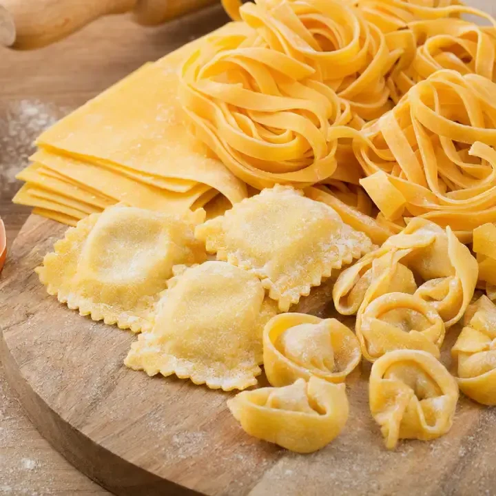 Fresh egg pasta rolled out on a wooden pasta board